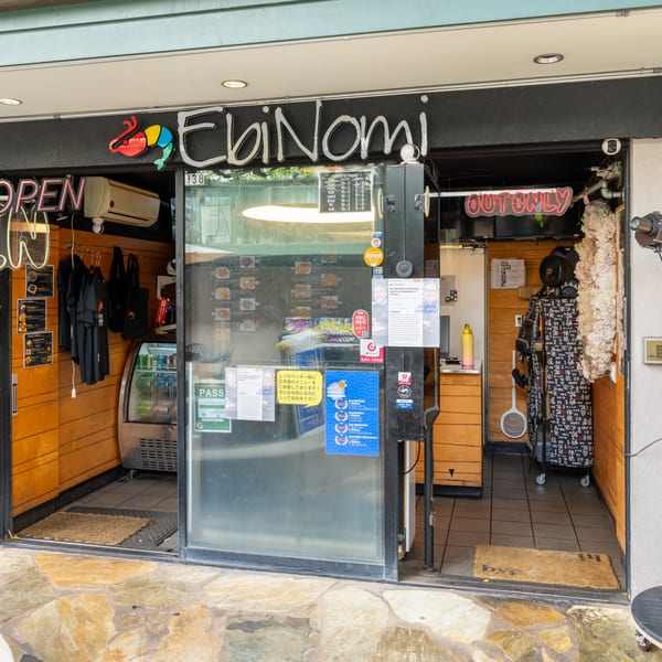 The storefront of EbiNomi, a Japanese restaurant, with an "OPEN" sign and menu displays.