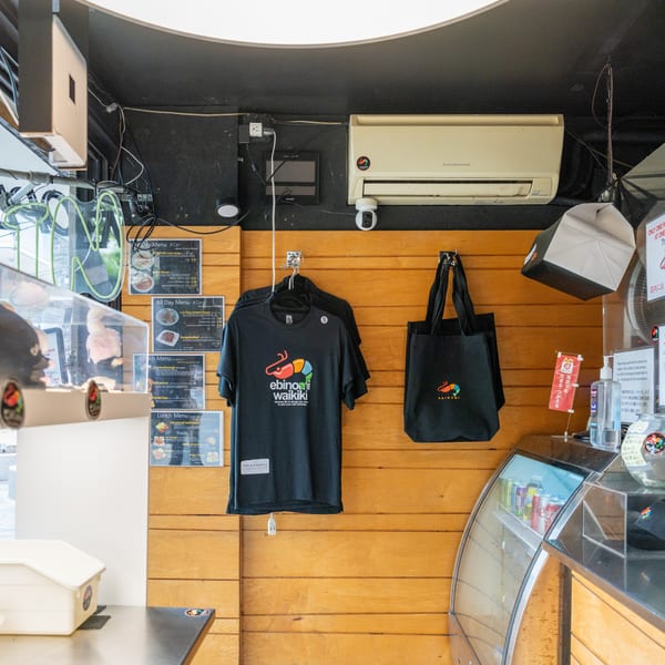 Interior of Ebinomi Waikiki, showing menus, branded merchandise, and a beverage cooler.