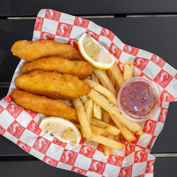 EbiNomi shrimp tempura and french fries with lemon wedges and dipping sauce in a branded basket.